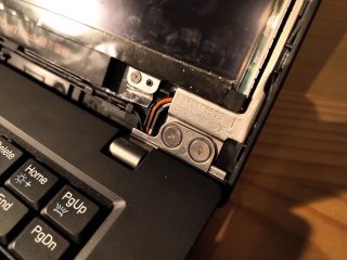 Pohled na zdroj praskavých zvuků. Slouží jako můstek pro spojení pantů se závěsy po stranách displeje.